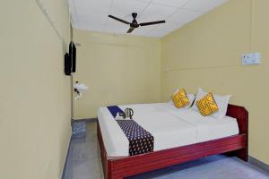 SPOT ON KVR Residency Near PVR Cinemas Skywalk tesisinde bir odada yatak veya yataklar