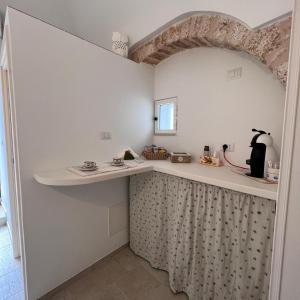 a small kitchen with a counter and a shelf at Trullo in Light in Alberobello