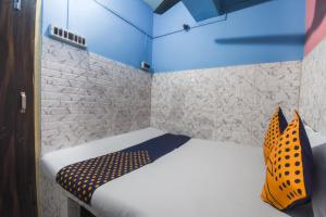 een kleine kamer met een bed en een blauw plafond bij OYO Hotel Sonar Bangla Lodge in Calcutta