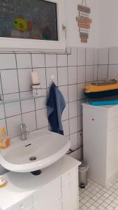 La salle de bains est pourvue d'un lavabo blanc. dans l'établissement Mensteder Utkiek, à Großheide