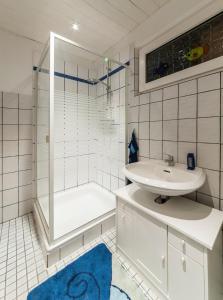 a white bathroom with a sink and a shower at Mensteder Utkiek in Großheide