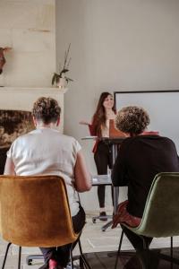 two people sitting at a table watching a woman giving a presentation at Château de La Vallade in Saint-Porchaire +53 photos