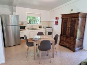 eine Küche mit einem Tisch und Stühlen sowie einem Kühlschrank in der Unterkunft Clandulla Cottages & Farmstay in Boyland