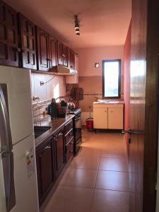 una cocina con armarios de madera y una pequeña ventana en Deptodivino en Villa Carlos Paz