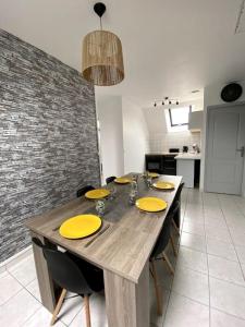- une table en bois avec des plaques jaunes dans la cuisine dans l'établissement L’escale proche château de chantilly, à Précy-sur-Oise