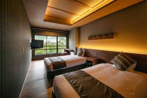 una camera d'albergo con due letti e una finestra di Unzen Fukudaya a Unzen