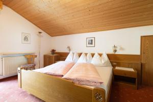 1 dormitorio con 1 cama grande y techo de madera en Pension Margreth, en Rifiano