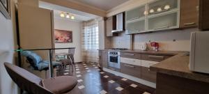 a kitchen with brown cabinets and a counter top at M.Dosoftei 126 in Chişinău