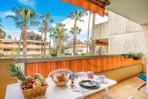 a table with food on a balcony with palm trees at Spacieux 3 pieces a 5 min des plages a pieds in Antibes