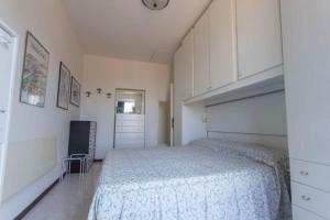 1 dormitorio con 1 cama, vestidor y reloj en Bilocale con ampio terrazzo, en Marciana Marina