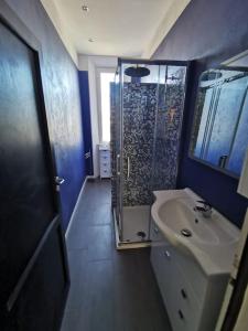La salle de bains bleue est pourvue d'une douche et d'un lavabo. dans l'établissement La casa del Lubra, à Piombino