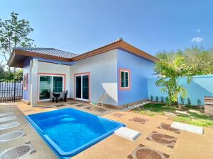 a house with a swimming pool in front of it at Blue Aura Pool Villa in Nai Yang Beach