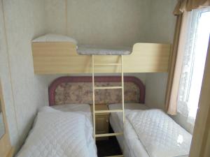Una cama o camas en una habitación de 10 Berth on Coastfields with free WiFi Status