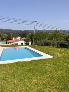 a small swimming pool in a field of grass at Casa dos Doces in Póvoa de Lanhoso