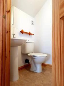 La salle de bains est pourvue de toilettes blanches et d'un lavabo. dans l'établissement OneRavensLane, à Stornoway