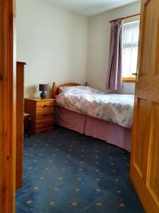 - une chambre avec un lit, une commode et une fenêtre dans l'établissement OneRavensLane, à Stornoway