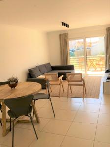 a living room with a couch and a table and chairs at Sea Avenue House - center Baleal - walk to surf in Ferrel