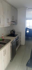 a kitchen with white cabinets and a stove top oven at Blue Largo Sea View in Westbrook