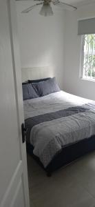 a bed in a white bedroom with a window at Blue Largo Sea View in Westbrook