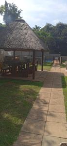 a picnic table with a straw hut in a park at Blue Largo Sea View in Westbrook