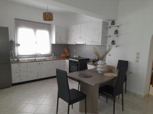 una cucina con tavolo e sedie di Giotouli Apartment a Afantou