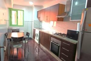 a kitchen with a table and a kitchen with a refrigerator at Apartamento en Majorelle, Marrakech. in Marrakesh