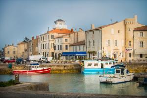 圣马丹德雷LE LANTERNON的两艘船停靠在一座有建筑物的港口