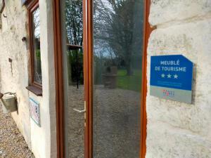 un cartel en la puerta de una casa con una ventana en Domaine Jasmin, 6 Gîtes typiquement Charentais avec Piscines, en Bellon