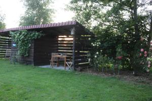 een houten schuur met een tafel in een tuin bij Mensteder Utkiek in Großheide