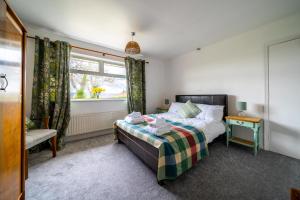 um quarto com uma cama e uma janela em Jane & Julies place em Gresford