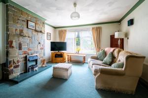 a living room with a couch and a fireplace at Jane & Julies place in Gresford