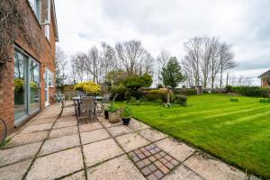 a patio with a table and chairs in a yard at Jane & Julies place in Gresford
