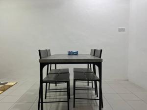 una mesa con dos sillas y una caja en ella en Villa Anggun, en Papar