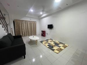 uma sala de estar com um sofá e uma mesa em Villa Anggun em Papar