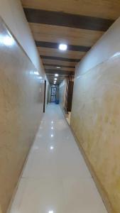 um corredor de um edifício com um longo piso branco em OYO Rajeswari Continental em Kanpur