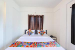 那格浦爾的住宿－FabHotel Elite Palm，一张床上有色彩缤纷的枕头