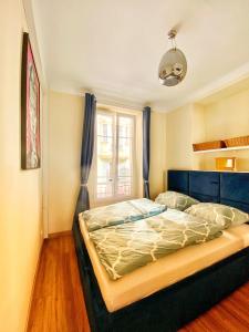 una camera da letto con letto con testiera blu e finestra di NEW! Beautiful Apartment - 1 minute to Monte Carlo a Beausoleil