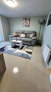 a living room with a couch and a table at Appart 2 chambres avec extérieur in Cherbourg en Cotentin