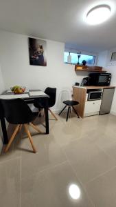 a kitchen with a table and chairs in a room at Appart 2 chambres avec extérieur in Cherbourg en Cotentin