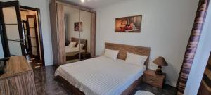 a bedroom with a white bed and a mirror at M.Dosoftei 126 in Chişinău
