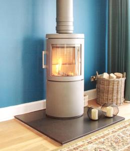a oven with a fire in it sitting on the floor at STUNNING LODGE MINUTES FROM THE SEA AND GOLF COURSE in Longniddry