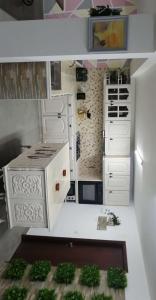 uma cozinha com armários brancos e plantas verdes em La maison du bonheur em Celavisa