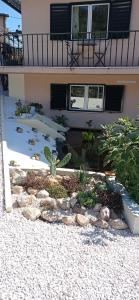 a garden in front of a house with rocks at La maison du bonheur in Celavisa