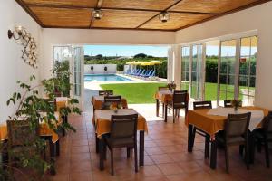 a restaurant with tables and chairs and a swimming pool at Mira Parque in Albufeira