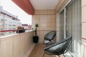 a balcony with two chairs and a window at Premium Flat in Upscale Area, Balcony, Parking in Lisbon