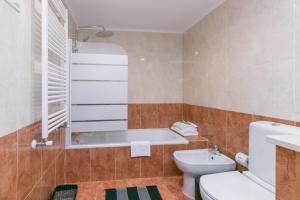 a bathroom with a tub and a toilet and a sink at Premium Flat in Upscale Area, Balcony, Parking in Lisbon