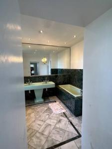 y baño con bañera, lavamanos y bañera. en Magnifique, logement Melun, en Le Mée-sur-Seine