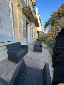 un patio con 2 sillas y un sofá junto a un edificio en Magnifique, logement Melun, en Le Mée-sur-Seine