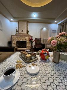 una sala de estar con una mesa con comida. en Caravan Castle Boutique Hotel, en Bukhara