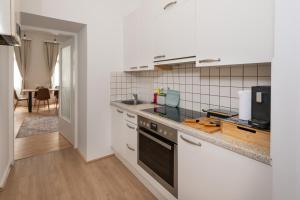 a kitchen with white cabinets and a counter top at ROKSOX-Home Meidling Schloss Schönbrunn in Vienna